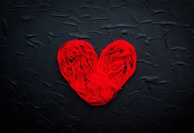 Sağlık, tıp, insanlar ve kardiyoloji konsepti. Soyut kırmızı kalp. Kalp sorunları var. Kalp ve kardiyogram kırmızı iplikten yapılır. Coronavirus COVID-19