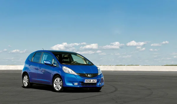 KIEV, UKRAINE-JULY 4.2017: Mavi araba Honda Jazz güneşli gökyüzünün arka planına karşı yolda park etti. Otomotiv fotoğrafçılığı. Mesaj için yer var. Arabalı arkaplan. 