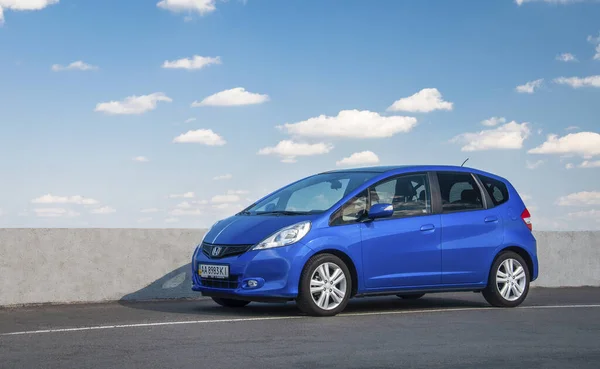 KIEV, UKRAINE-JULY 4.2017: Mavi araba Honda Jazz güneşli gökyüzünün arka planına karşı yolda park etti. Otomotiv fotoğrafçılığı. Mesaj için yer var. Arabalı arkaplan. 