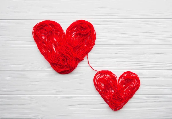 Health, medicine, people and cardiology concept. Abstract red hearts. Problems with heart. Hearts is made of red thread. Charity, health care, donation concept.
