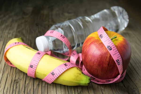 Concepto de alimentación saludable, cinta métrica, fruta y botella de agua en —  Fotos de Stock