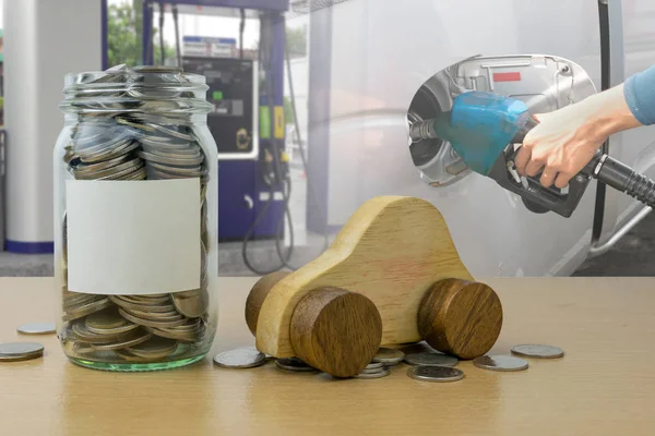 Garrafa de dinheiro com moedas na mão segurando Bocal de combustível derramando — Fotografia de Stock