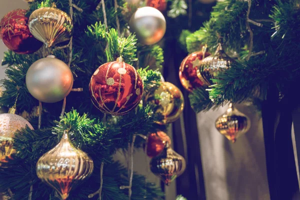 Μπιχλιμπίδι που κρέμονται από ένα στολισμένο χριστουγεννιάτικο δέντρο. Θόλωμα και ρετρό f — Φωτογραφία Αρχείου