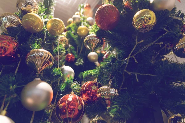 Christbaumkugeln hängen an einem geschmückten Weihnachtsbaum. Unschärfe und Retro — Stockfoto