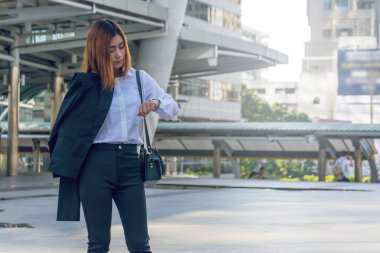 Genç iş kadını saatini zamanında kontrol.