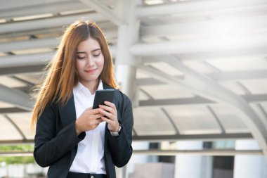 İş kadını akıllı telefonunu kullanıyor.