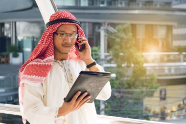Arap işadamı Tablet ve cep telefonu kullanarak.