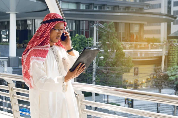 Arabisk affärsman med surfplatta och mobil telefon. — Stockfoto