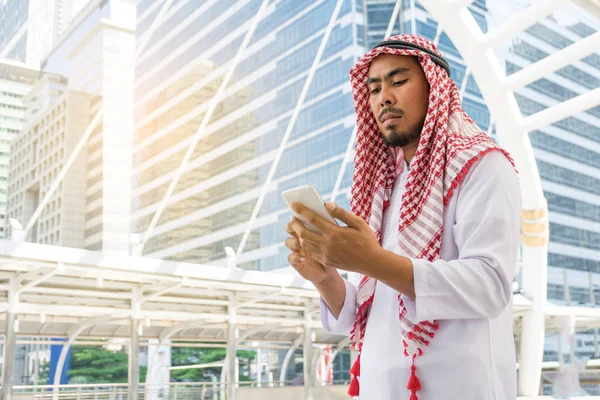 Arabisk affärsman meddelanden på en mobiltelefon i staden — Stockfoto