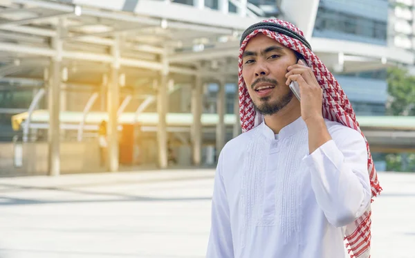 Arabisk affärsman meddelanden på en mobiltelefon i staden — Stockfoto