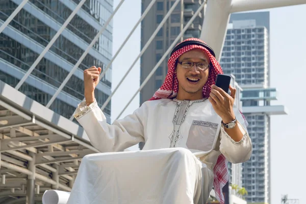 Arabisk affärsman meddelanden på en mobiltelefon i staden — Stockfoto