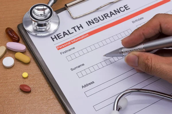 Health insurance paperwork, medicine, stethoscope. Health insura