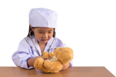 Asyalı kız doktor bakım ayı bebek gibi oynamak