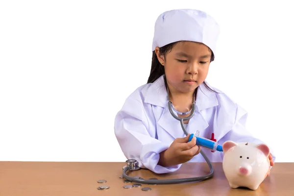 Menina asiática jogando como um médico cuidado Piggy Bank, isolado backgro — Fotografia de Stock