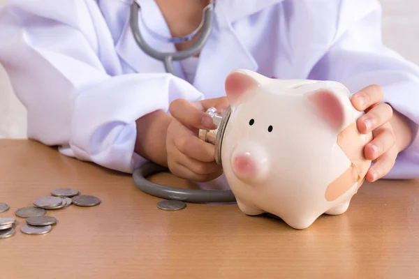 Asiatique fille jouer comme un médecin soins Piggy Bank — Photo