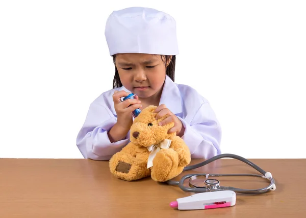 Asiático chica jugando como un médico cuidado oso muñeca —  Fotos de Stock