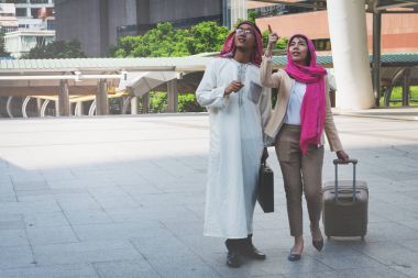 Arap adam ve bir çanta taşıyan yürüyen kadın