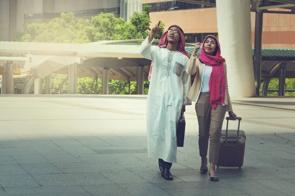 Uomini e donne arabi che camminano portando una valigia — Foto Stock