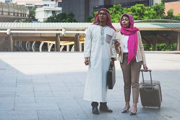 Uomini e donne arabi che camminano portando una valigia — Foto Stock