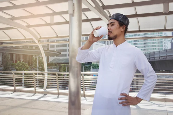 muslim man drink coffee in city