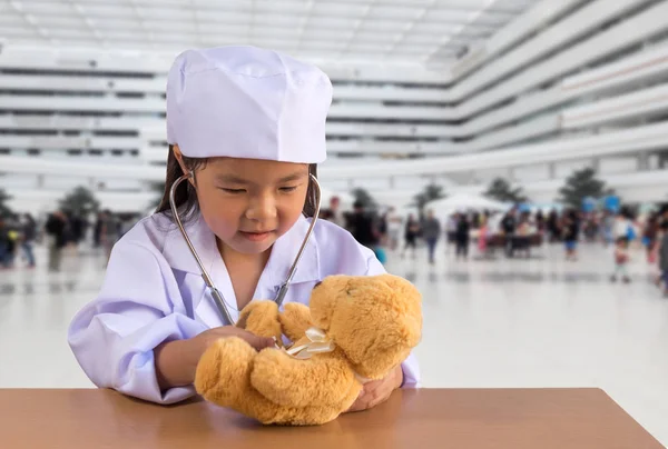 Asiático chica jugando como un médico cuidado oso muñeca —  Fotos de Stock