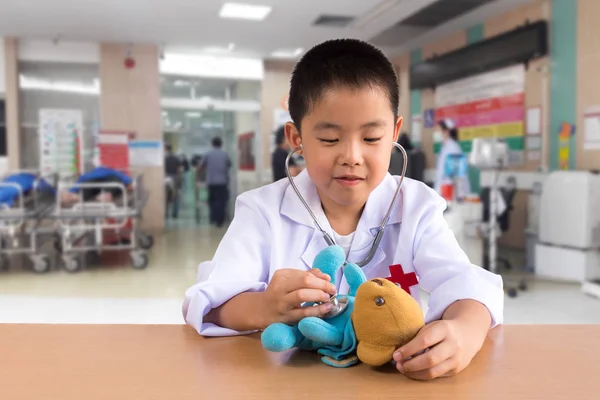 Asiático chico jugando como un médico cuidado oso muñeca —  Fotos de Stock