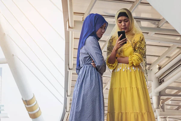 Donne musulmane messaggistica su un telefono cellulare in città . — Foto Stock