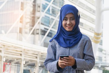 Müslüman kadının şehirde bir cep telefonuna ileti