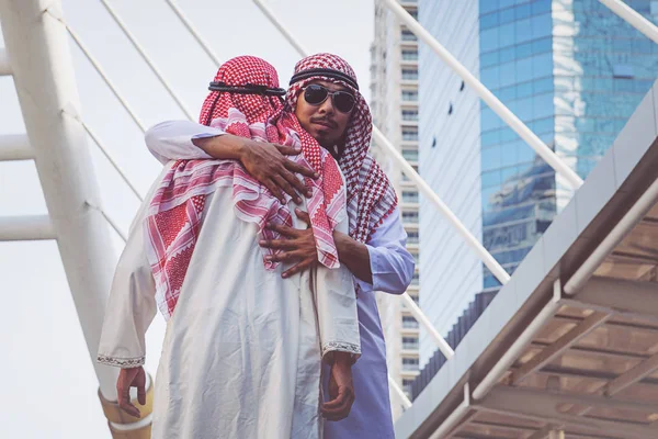 Two Arab businessmen Greet with a hug, on city background — Stock Photo, Image