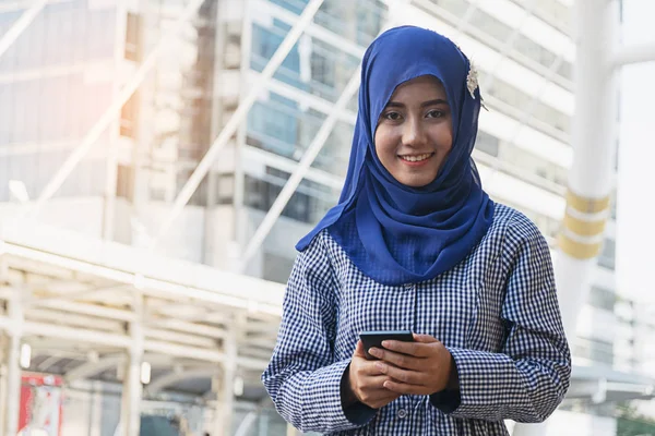 Donna musulmana messaggistica su un telefono cellulare in città — Foto Stock