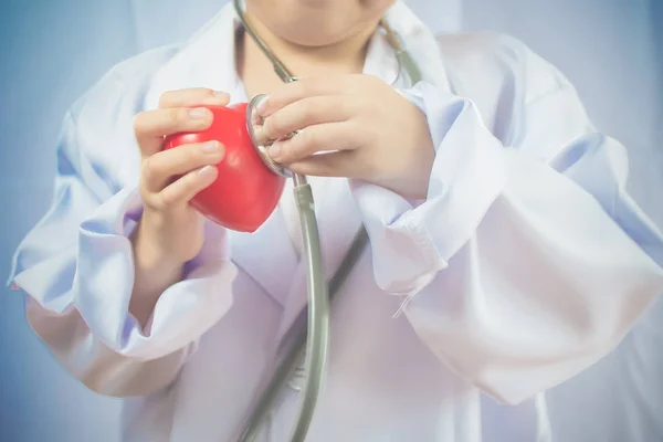 Asiática chica jugando como un médico cuidado saludable corazón —  Fotos de Stock