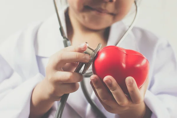 Asiática chica jugando como un médico cuidado saludable corazón — Foto de Stock