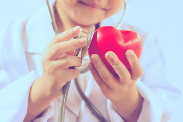 Asiática chica jugando como un médico cuidado saludable corazón — Foto de Stock