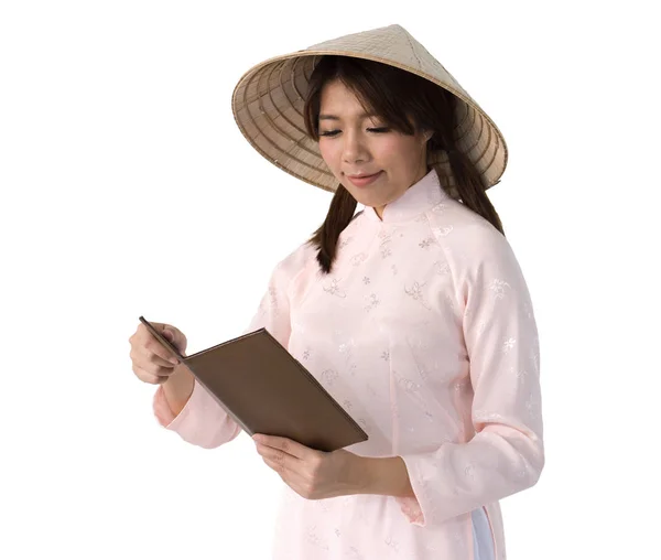 本を保持しているピンクのドレスとベトナムの帽子で美しい女性。isol — ストック写真