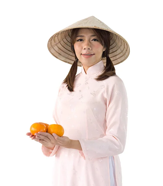 Hermosa mujer en vestido rosa y sombrero de Vietnam sosteniendo naranja. es —  Fotos de Stock