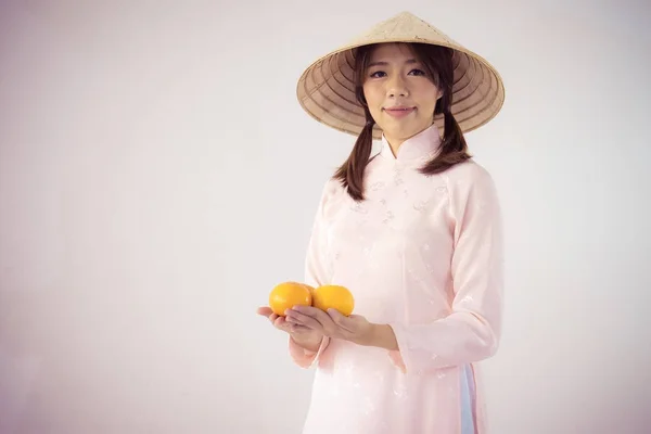 분홍색 드레스와 베트남 모자 오렌지를 들고 아름 다운 여자 — 스톡 사진