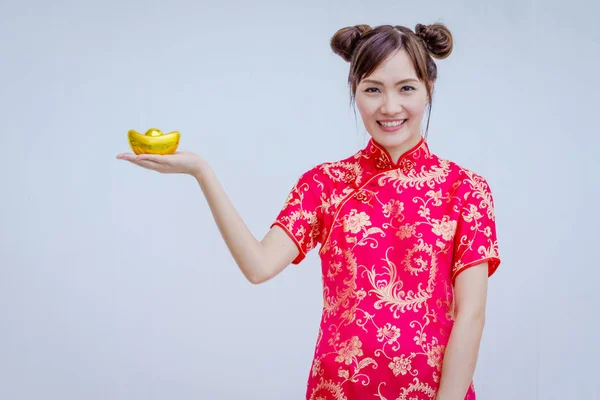 Mujer asiática con cheongsam sosteniendo oro. Año nuevo chino . — Foto de Stock