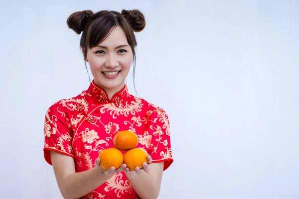 Mujer asiática con cheongsam sosteniendo naranja. Año nuevo chino . — Foto de Stock