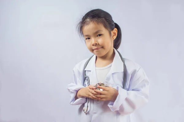 Азиатская девушка играет в качестве врача заботятся о деньгах в чашке — стоковое фото
