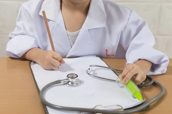 Aziatisch meisje dragen als arts schrijven recept en preparin — Stockfoto