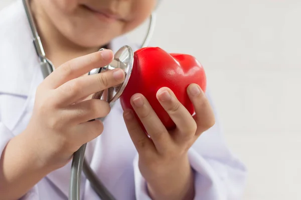 Menina asiática jogando como um médico cuidar coração saudável — Fotografia de Stock