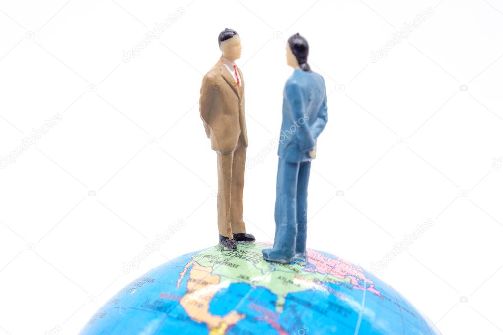 Miniature businessman on the globe on white background