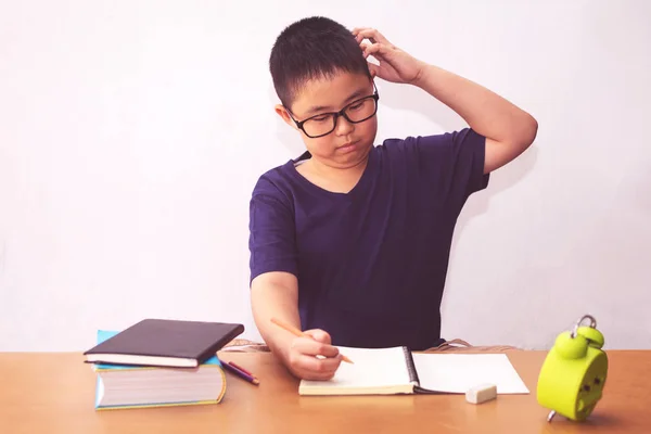 Aborrecido e cansado asiático estudante menino fazendo lição de casa — Fotografia de Stock