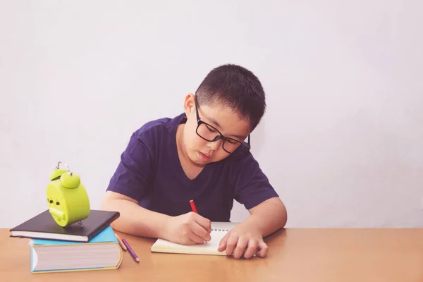 Asiático chico escribiendo un libro en la mesa — Foto de Stock