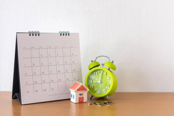 Kalender och hus på bordet. Dagen för köp eller försäljning av ett hus eller — Stockfoto