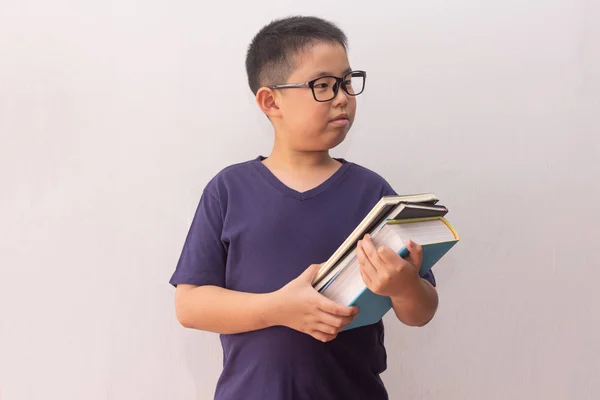 Азіатський хлопчик тримає книжки готові до школи — стокове фото
