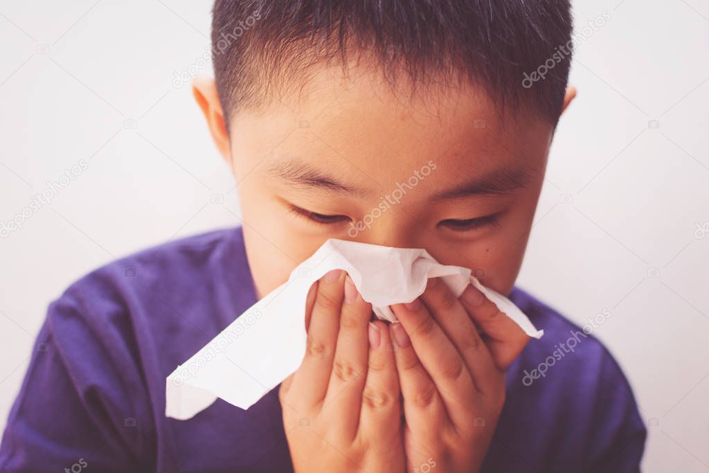 Asian boy cold flu illness tissue blowing runny nose