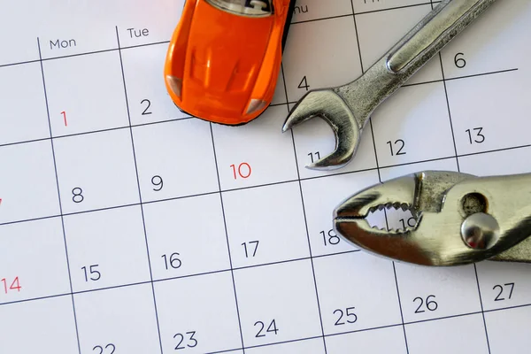 wrench and car on the calendar with numbers. repair concept