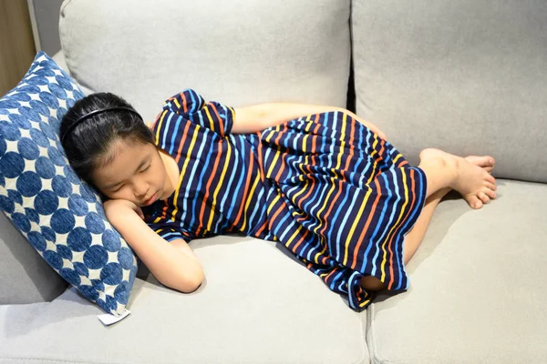 Little asian girl sleeps on a couch — Stock Photo, Image