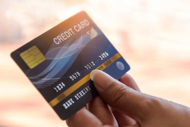 Bilgisayarda kredi kartı tutan bir kadın. İnternetten bilgisayar kullanarak alışveriş yapmak.